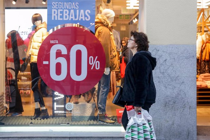 Una dona passeja al costat d'una botiga de moda de Madrid.