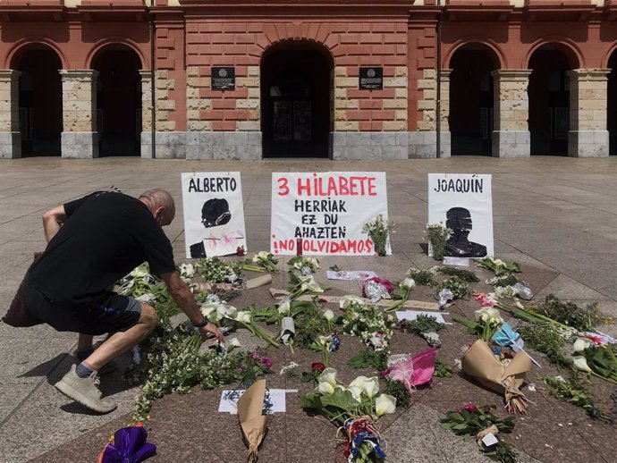 Un hombre deposita unas flores en el homenaje en la plaza de Unzaga de Eibar a los dos trabajadores que siguen sepultados en el vertedero de Zaldibar cuando se cumplen 3 meses del desprendimiento 