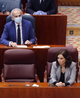 La presidenta de la Comunidad de Madrid, Isabel Díaz Ayuso (d) junto a su consejero de Sanidad, Enrique Ruiz Escudero (atrás) durante el pleno en la Asamblea de Madrid.