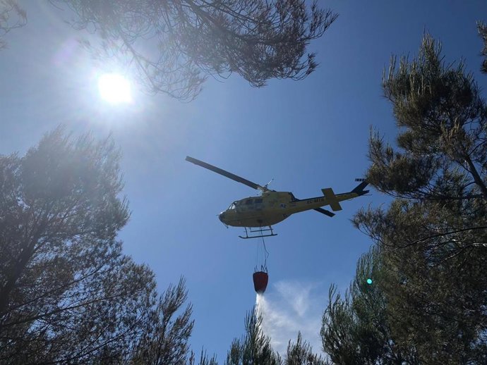 Un helicóptero descarga sobre el incendio del Camí de Cabanes de Xbia.