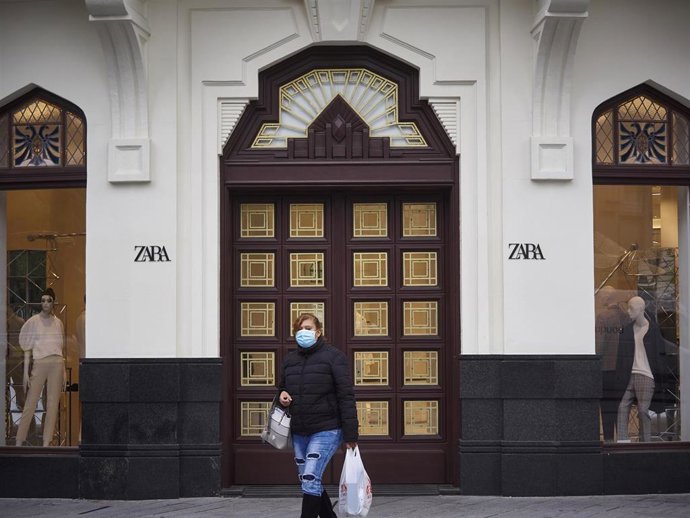 Una mujer pasa junto a una tienda Zara cerrada el día en el que la capital navarra pasa junto el resto de la comunidad a la Fase 1 del Plan de Desescalada establecido por el Gobierno de España. En Pamplona/Navarra (España) a 11 de mayo de 2020.