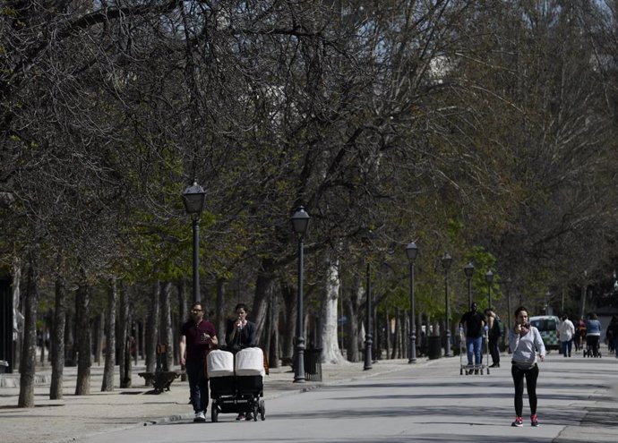 Unos padres pasean a sus hijos en sillita de bebé por el Parque del Retiro, en Madrid (España) a 11 de marzo de 2020.