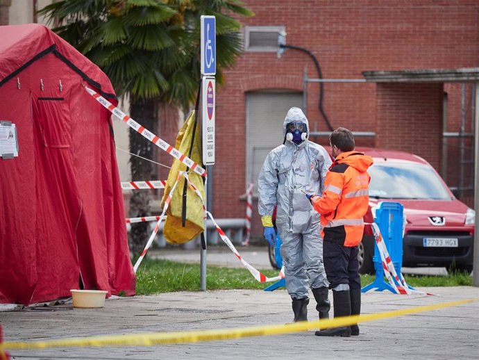Un sanitario se protege con traje EPI y máscara cerca de la zona de desinfección del Complejo Hospitalario de Navarra durante a Pandemia Covid-19.