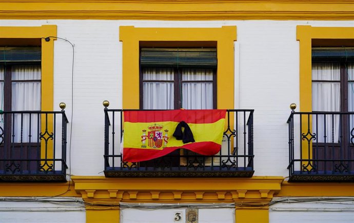 Banderas de España con crespones negros en algunos balcones de Sevilla a 13 de abril del 2020