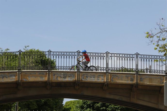 Un niño monta en bicicleta sobre un puente en Palma.