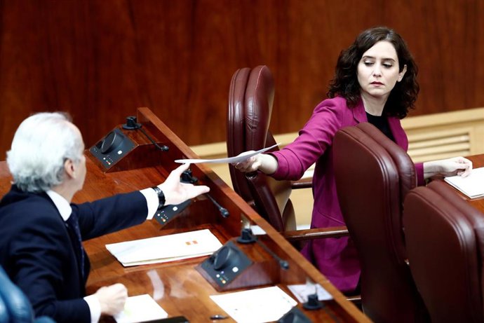 La presidenta de la Comunidad de Madrid, Isabel Díaz Ayus le entrega un papel al consejero de Sanidad, Enrique Ruiz Escudero