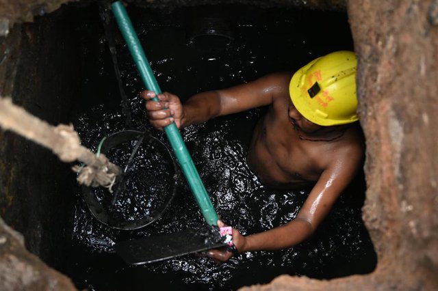 23 April 2020, India, Prayagraj: A municipal corporation worker clean a sewer during a nationwide lockdown to prevent the spread of Coronavirus (Covid 19). Photo: Prabhat Kumar Verma/ZUMA Wire/dpa