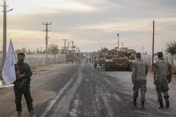 Soldados y vehículos militares de Turquía en una zona de estacionamiento para el Ejército y los rebeldes a los que apoya Ankara en Siria cerca de la frontera con el país árabe