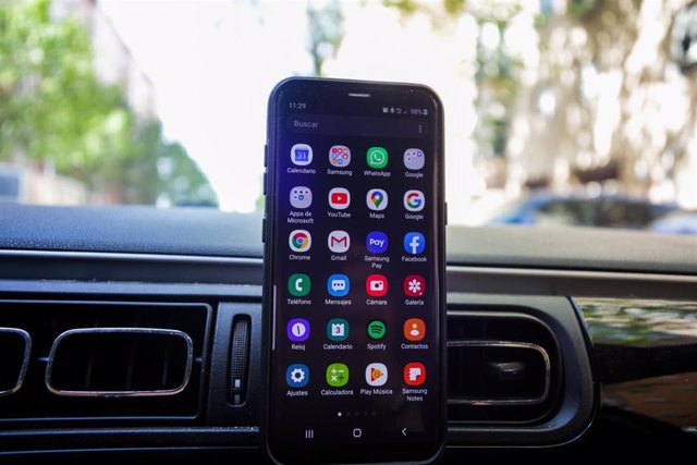 Un 'smartphone' con el menú de aplicaciones abierto colocado en un coche