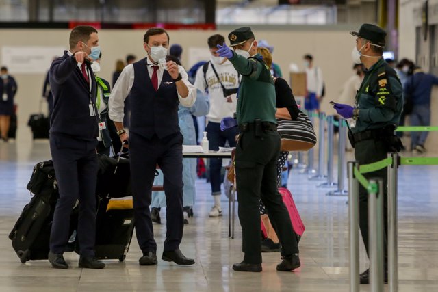 Agentes de la Guardia Civil de la Jefatura Fiscal y de Fronteras ayudan a viajeros en la terminal 4 del Aeropuerto de Madrid-Barajas Adolfo Suárez.