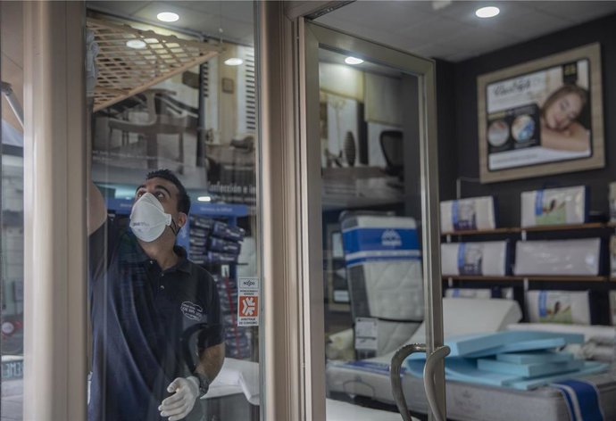 Un empleado de una tienda de artículos para el hogar limpia el local para poder abrir próximo lunes 11 de mayo. En Sevilla, (Andalucía,España), a 08 de mayo de 2020.