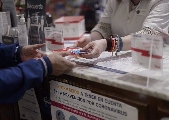 Una persona recoge una mascarilla de la Farmacia CEA, una de las 2.882 farmacias madrileñas que desde el pasado lunes han entregado de forma gratuita siete millones de mascarillas FFP2 modelo KN95. En Madrid, (España), a 12 de mayo de 2020.