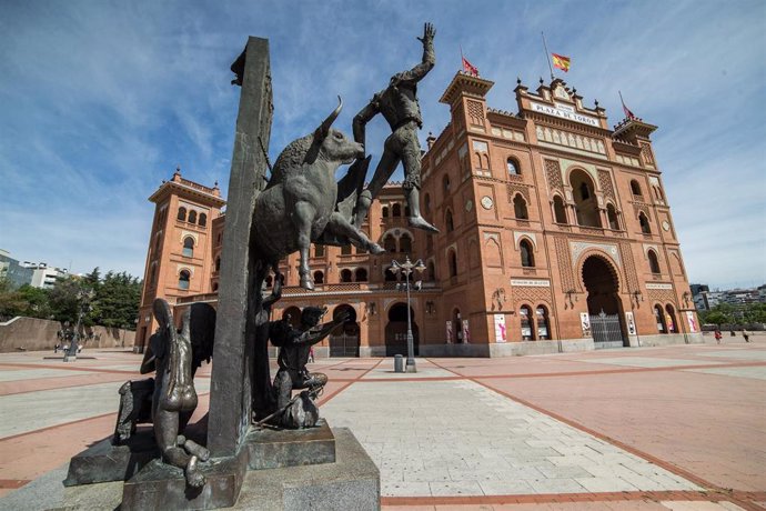 Varias personas caminan junto a la Plaza de Toros de Las Ventas, donde se encuentra la estatuta del torero José Cubero Yiyo, obra del escultor Luis Sanguino