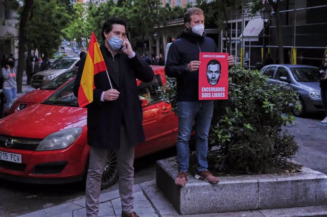 Dos hombres durante la concentración de protesta contra Sánchez en la calle Núñez de Balboa de Madrid. 
