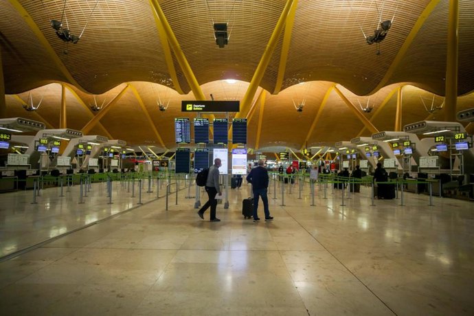 Viajeros en la terminal 4 del Aeropuerto de Madrid-Barajas Adolfo Suárez en el día en el que entra en vigor la orden del Ministerio de Sanidad por la que todas las personas procedentes del extranjero deberán realizar una cuarentena.