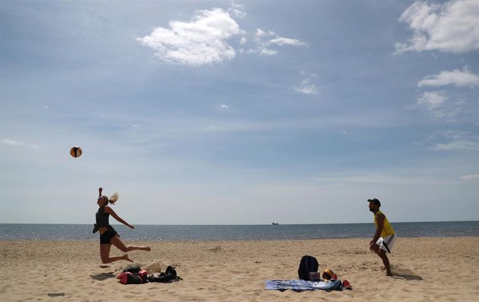 Imagen de dos personas jugando al volleyball en la playa en Reino Unido, uno de los países más afectados por el coronavirus. 
