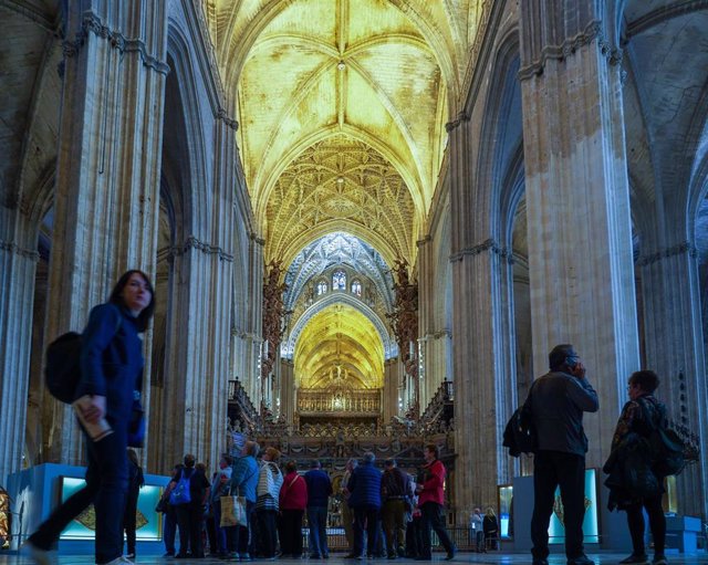 Turistas dentro de La Catedral de Sevilla, foto de archivo