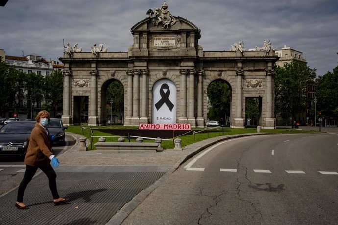 Una mujer camina al lado de la Puerta de Alcalá el mismo día en que se han peatonalizado diversas vías a causa de la distancia de seguridad exigida por el Covid-19 y que se amplían este fin de semana de 29 a 36 calles abiertas para peatones, con más met