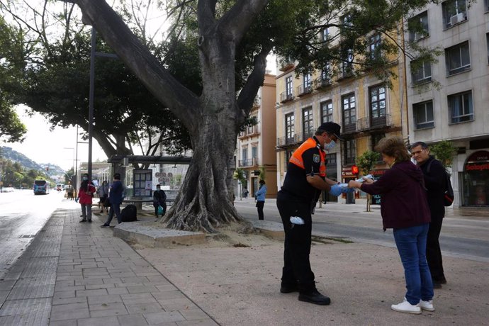 Miembros de protección civil de Málaga entregan mascarillas a los pasajeros de autobuses, durante la fase 0 de la desescalada del Gobierno. En Málaga(Andalucía, España), a 04 de mayo de 2020.
