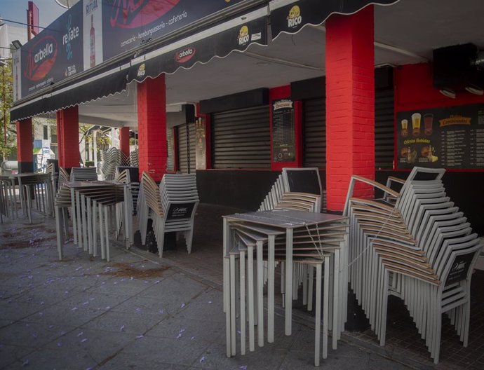 Sillas y mesas apiladas en la terraza de un bar a 30 de abril de 2020.
