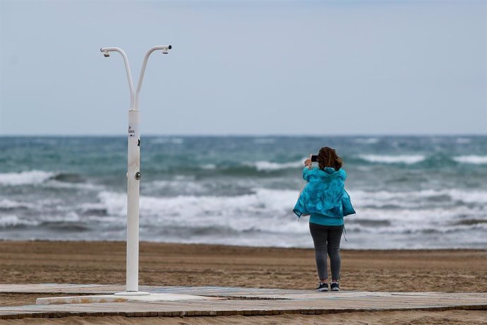 Una mujer hace una foto de la playa de la Marlvarros completamente vacía durante las últimas horas de Fase 0 en la desescalada de Valencia instaurada por el Gobierno para prevenir el coronavirus, pasando a Fase 1 a partir del próximo lunes. En Valencia 