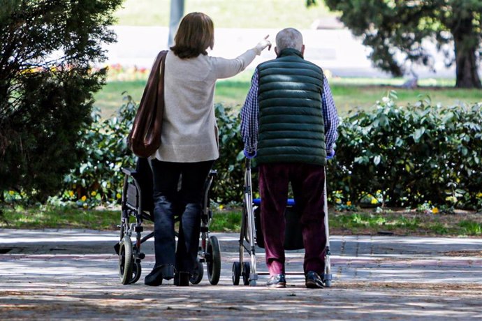 Un anciano y una mujer en el primer día en que los españoles pueden salir de casa a pasear y hacer ejercicio al aire libre, pero solo en determinadas franjas horarias, divididos por edades.