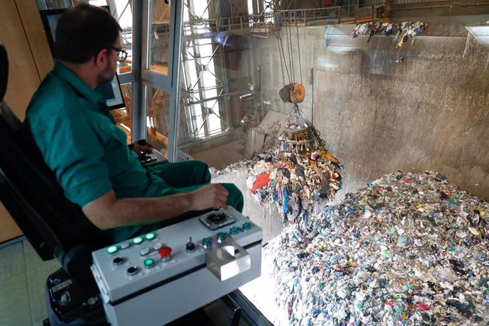 Un trabajador del Parque Tecnológico de Valdemingómez, mueve desde una grua una montaña de residuos. 