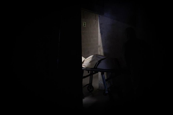 Varios operarios protegidos de los Servicios Funerarios Memora trasladan un cuerpo. En Girona, Cataluña, (España), a 6 de mayo de 2020.