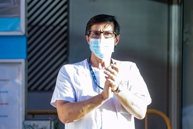 Un sanitario del Hospital General Universitario Gregorio Marañón y un transeúnte aplauden a las puertas del hospital. En Madrid (España) a 17 de mayo de 2020.
