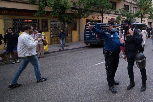 Un agente de Policía Municipal hace indicaciones a uno de Policía Nacional en una protesta en la sede del PSOE en Madrid 