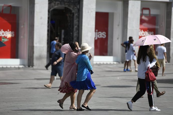 Turistas caminado en un día soleado en el centro de Madrid