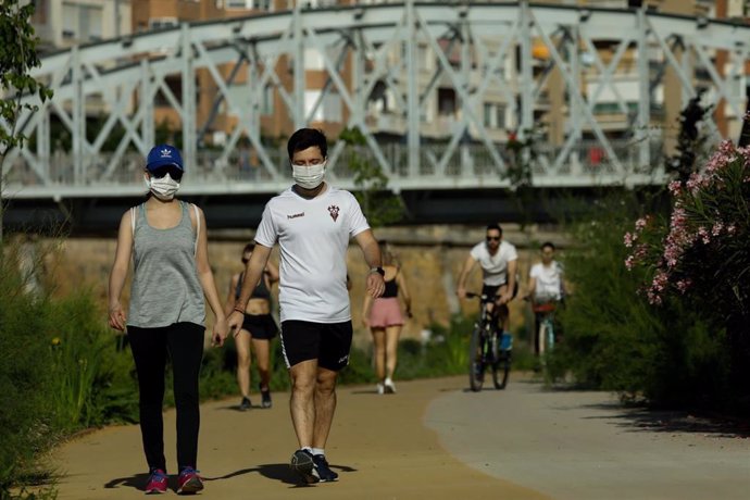 Personas haciendo deporte y paseando por la mota del río a su paso por Murcia