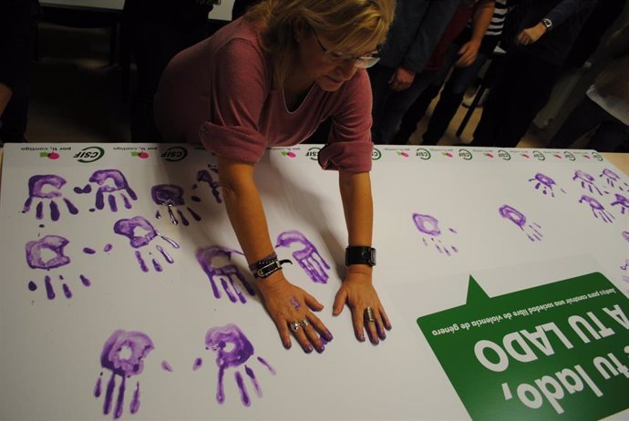 Delegados de CSIF en Valladolid muestran con sus manos moradas el rechazo de la violencia de género.