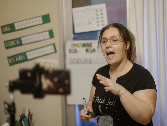 Una profesora de Educación Infantil graba con su móvil una clase para sus alumnos en Madrid durante el confinamiento.