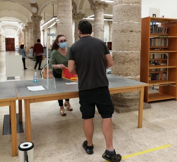 Un usuario devuelve un libro en una biblioteca pública