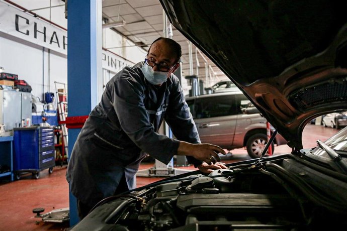 Un trabajador inspecciona un vehículo en talleres Otman