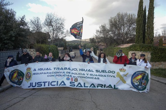 Miembros de la Asociación Jusapol sostienen una pancarta en la protesta frente a la casa de Pablo Iglesias e Irene Montero