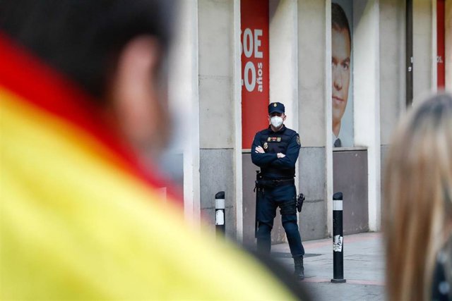 Un agente de la Policía en la sede del PSOE en una de las protestas contra el estado de alarma por el coronavirus