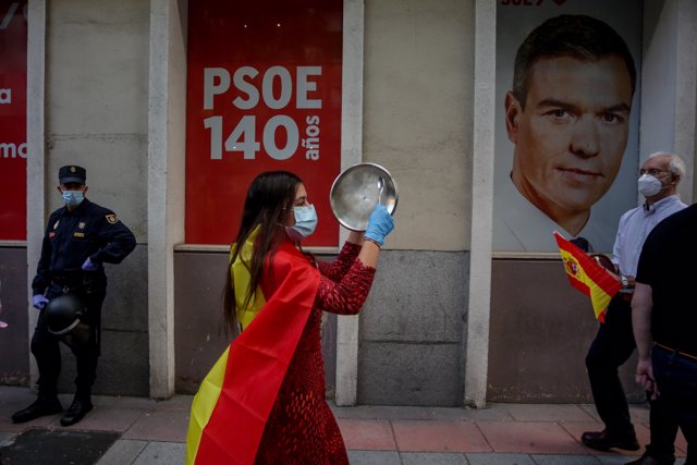Una mujer toca una cacerola durante el cuarto día de protestas por la gestión del Gobierno en la crisis del coronavirus, frente a la sede del PSOE de la calle Ferraz en Madrid a 19 de mayo de 2020.