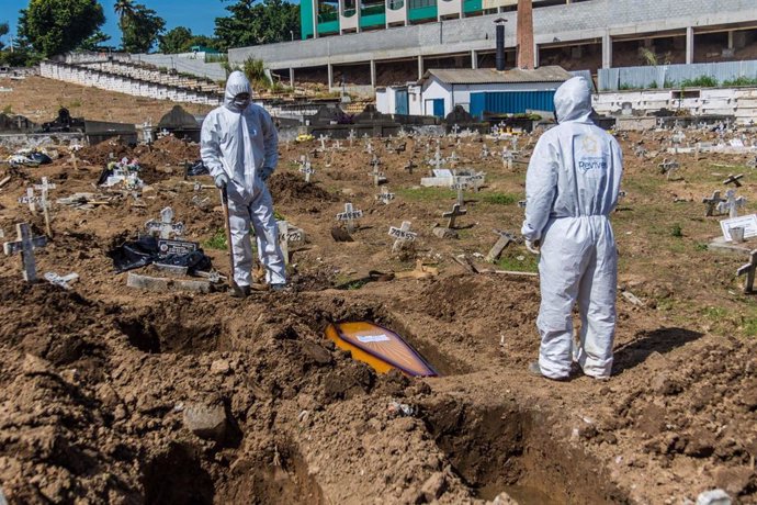 Dos trabajadores del cementerio de Sao Francisco Xavier, en Río de Janeiro, durante las labores de entierro de víctimas de la COVID-19.