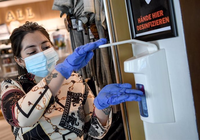 Una empleada se desinfecta con guantes en un restaurante de Berlín