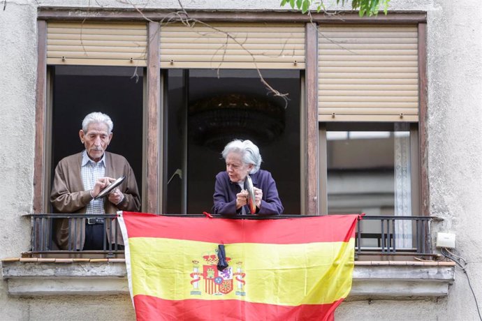 Un hombre y una mujer asomados a su balcón hacen sonar tapas de cacerolas durante la cacerolada contra la gestión del Gobierno en la crisis del coronavirus en la calle Ferraz de Madrid Madrid a 19 de mayo de 2020.