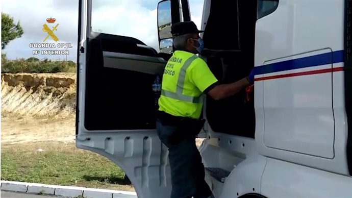 Agente de la Guardia Civil inspecciona el tacógrafo de un camión, que habría sido manipulado.