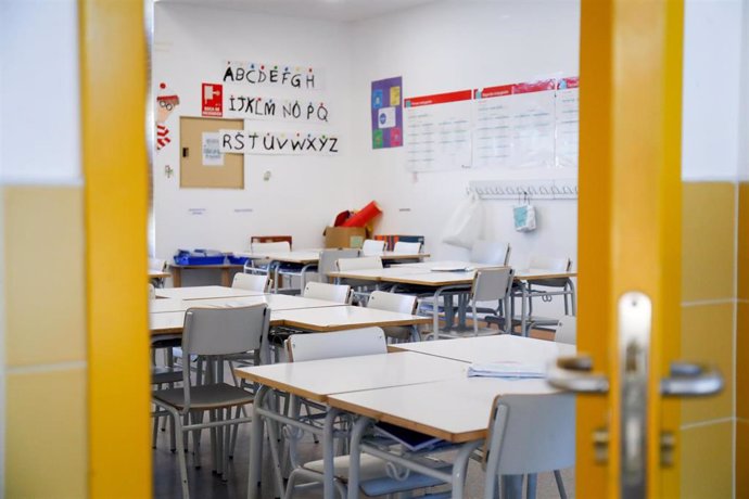 Sillas y mesas de un aula en el interior de un colegio.