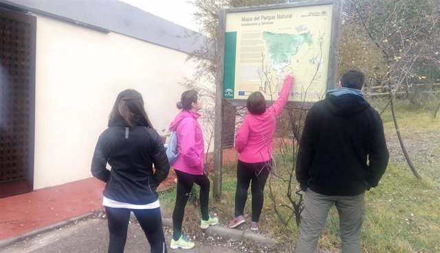 Varios visitantes consultan un mapa del Parque Natural Sierra de Andújar.