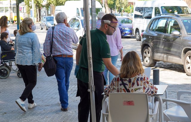 Un camarero con mascarilla atiende a un cliente  en la segunda semana de la fase 1 en Sevilla a 20 de mayo del 2020