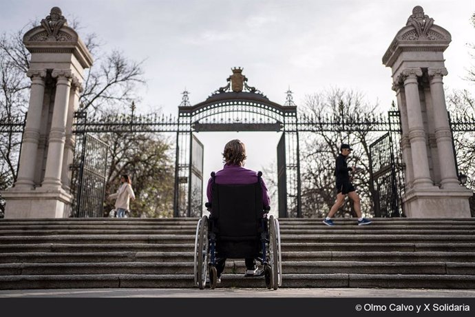 Cristina, en silla de ruedas, ante una escalinata en la Puerta de España del Parque del Retiro, en Madrid