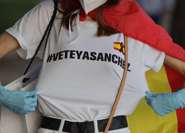 Una mujer muestra una camiseta durante una concentración contra la gestión de Pedro Sánchez y Pablo Iglesias en la pandemia en el Paseo de la Alameda de Valencia (España) el 18 de mayo de 2020.