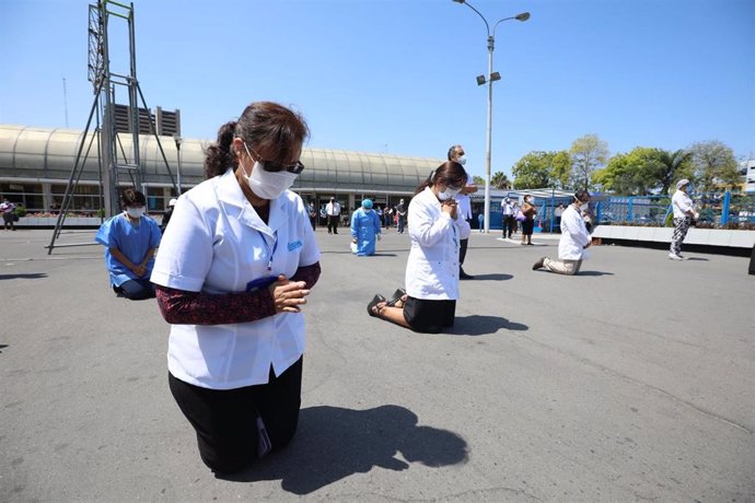 Un grupo de creyentes reza a las puertas de un hospital de Lima en el que están siendo tratados varios pacientes diagnosticados con la enfermedad del nuevo coronavirus.