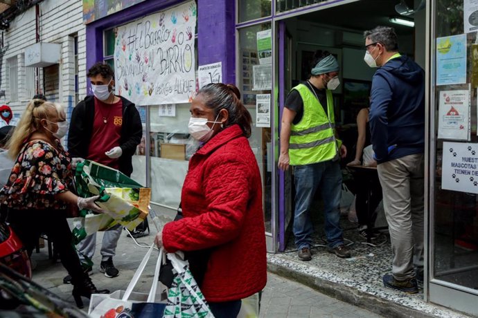 Voluntarios de la Asociación de Vecinos Parque Aluche entregan alimentos y productos donados en su sede ubicada en la calle Quero n 69 a aquellos vecinos del barrio que lo necesitan. En Aluche, Madrid, (España), a 16 de mayo de 2020.